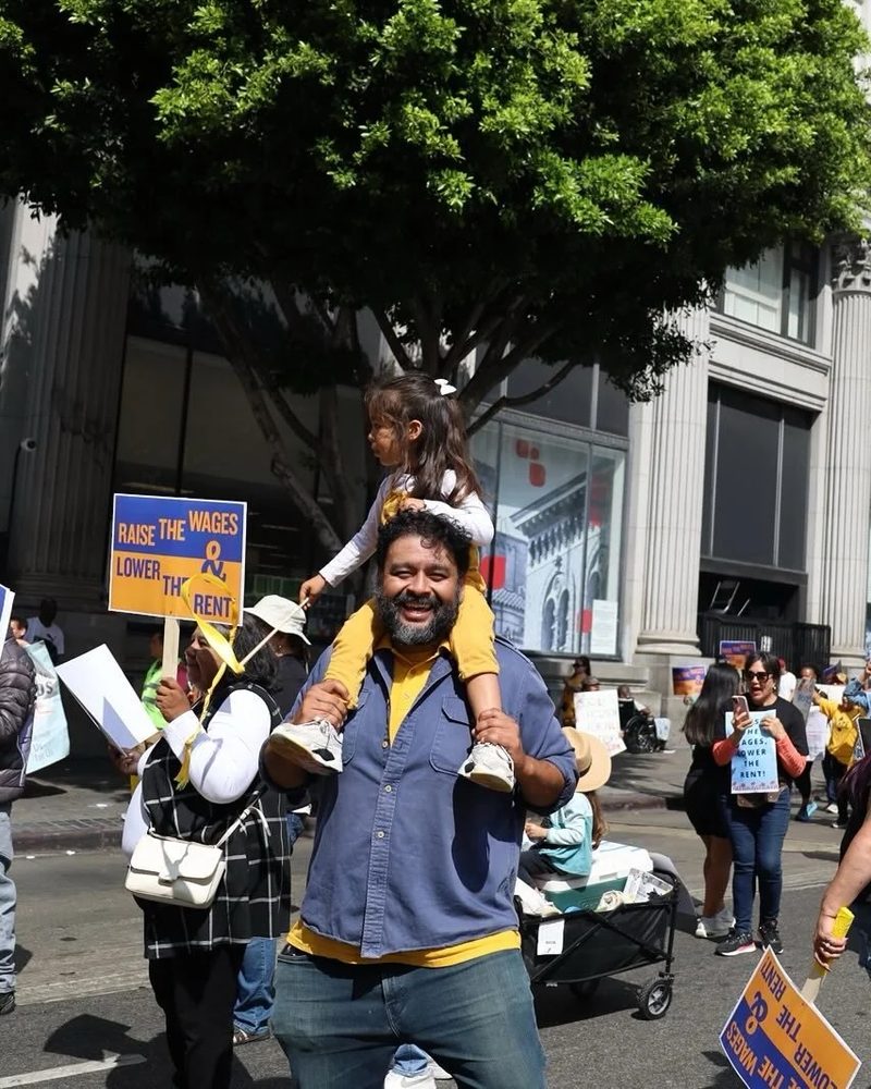 Estuardo Mazariegos carrying his daughter on his shoulders at a community march